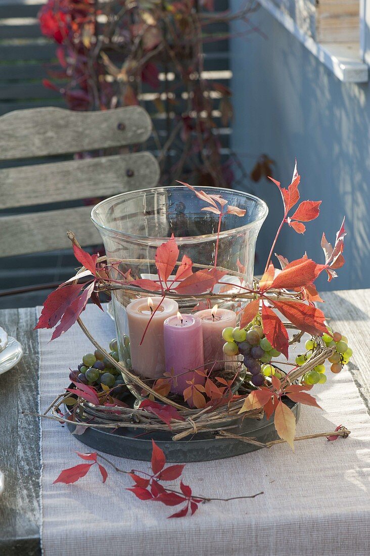 Large glass with candles as a lantern, decorated with grapes