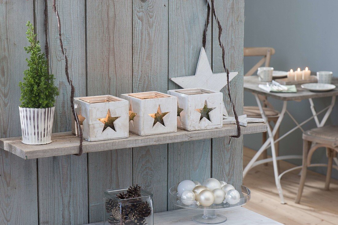 Lanterns with star decoration hanged on board on wall