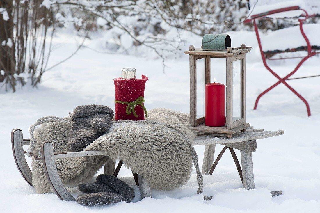 Sledge in the snow, fur, gloves, thermos in a felt coat,