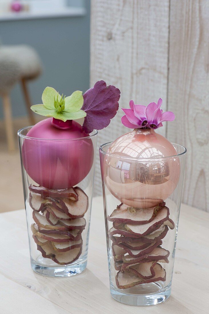 Apple slices and Christmas balls as vases in glasses