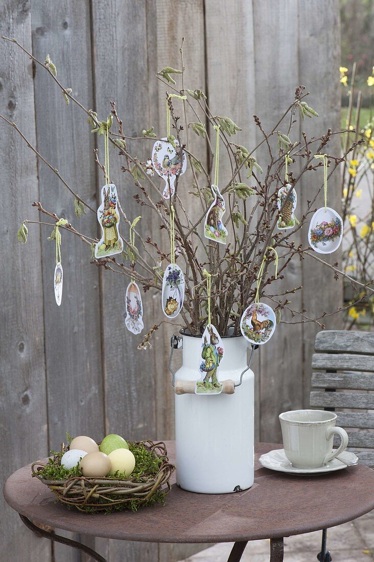 Easter bouquet of branches in old milk can, decorated with Easter wafers