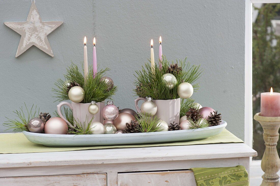 Adventsgesteck in Tassen auf Brotschale, dekoriert mit Christbaumkugeln