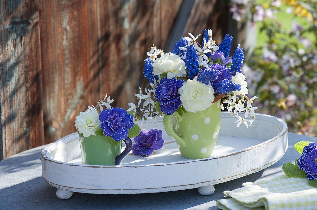 Small bouquets in cups on wooden tray