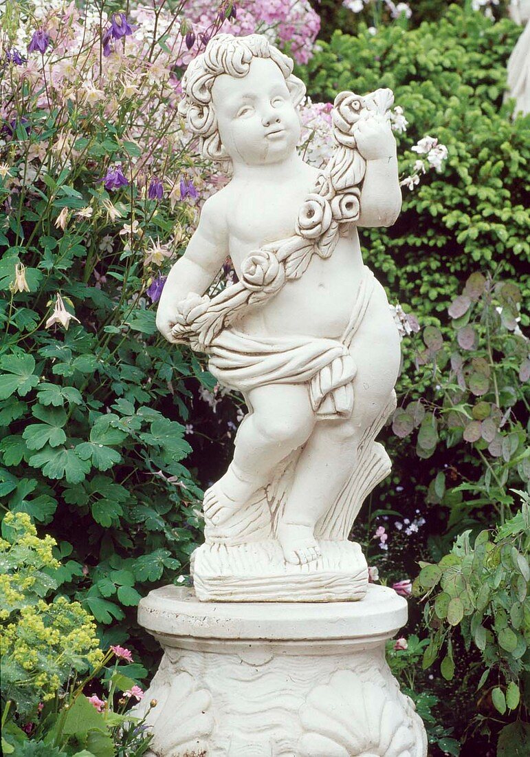 Cement figure-putty on pedestal in herbaceous border