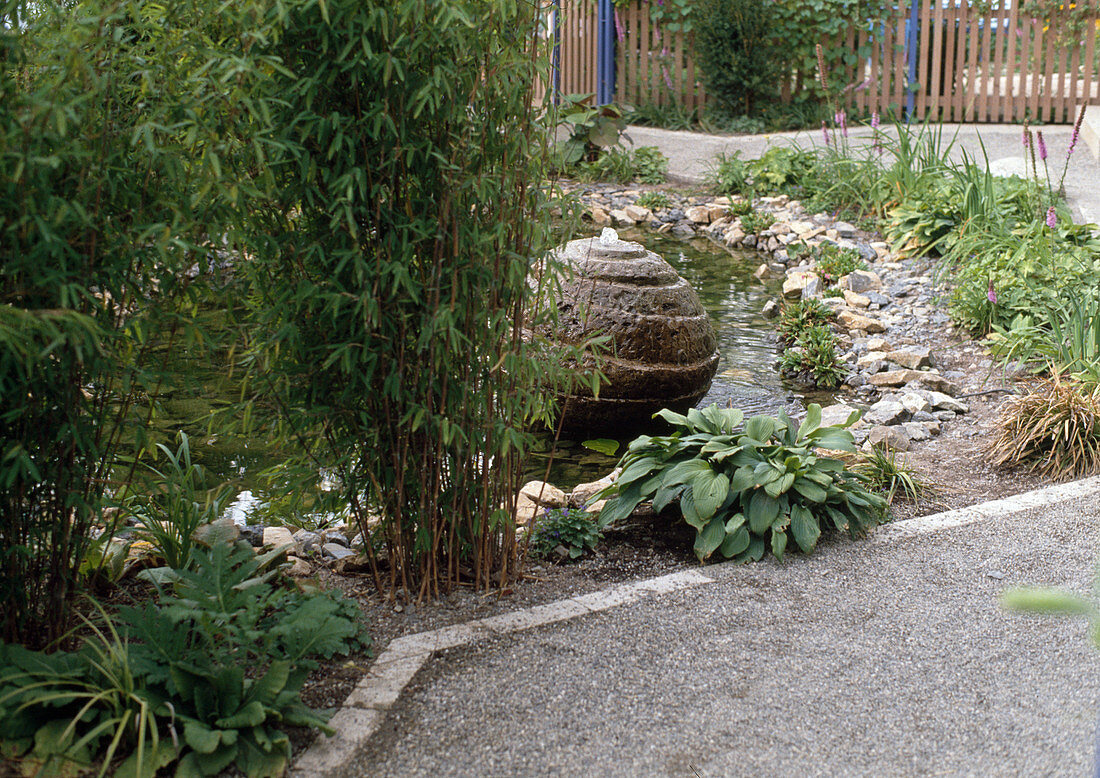 Teich im Garten mit Steinkugel als Wasserspiel