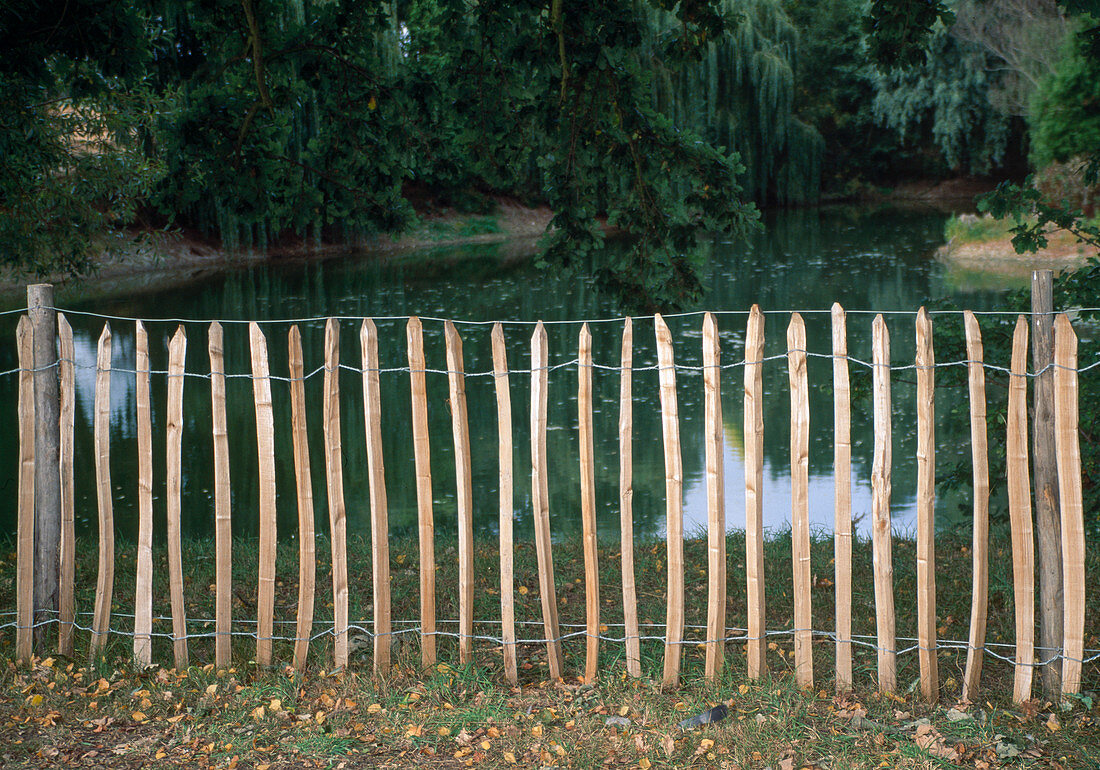 Simple picket fence as a barrier to the pond