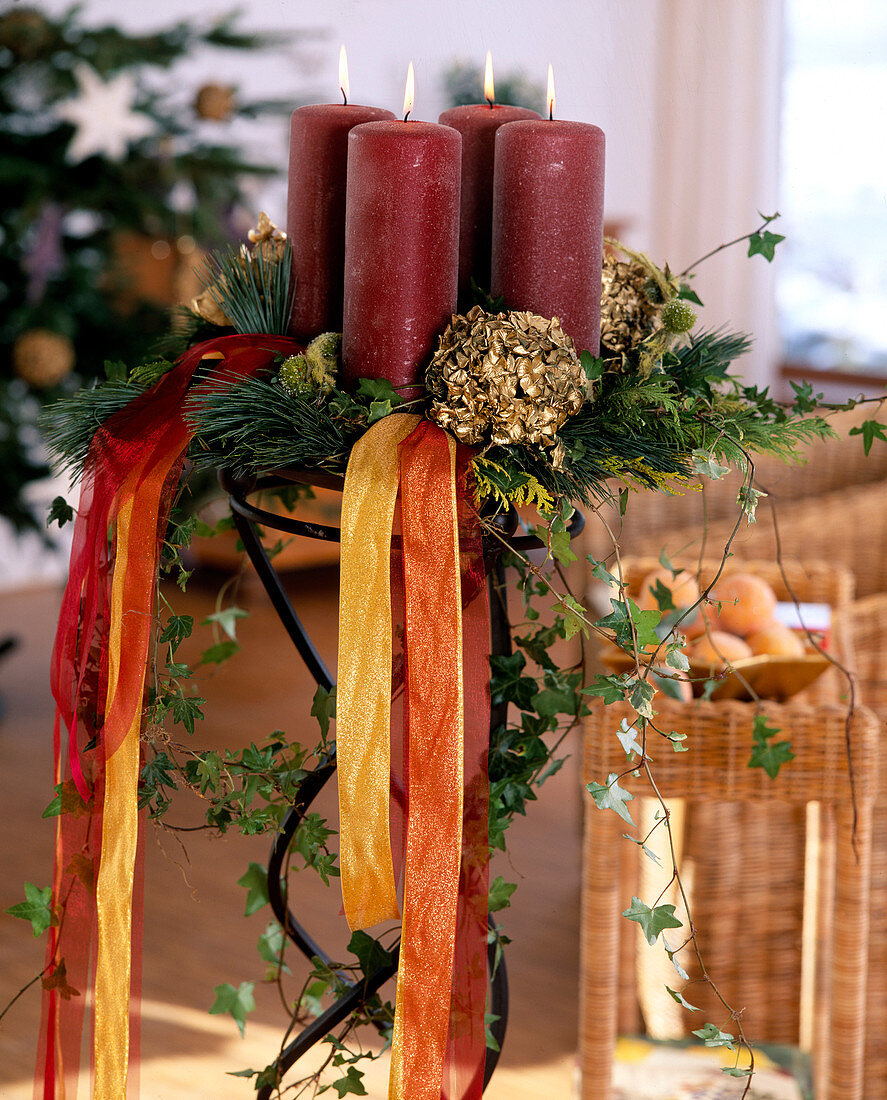 Christmas stand with fir branches, candles and ribbons