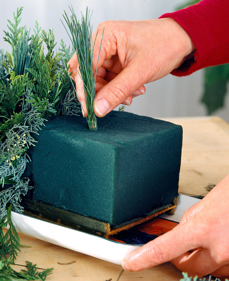 Advent arrangement: Pressing twigs into cutting compound