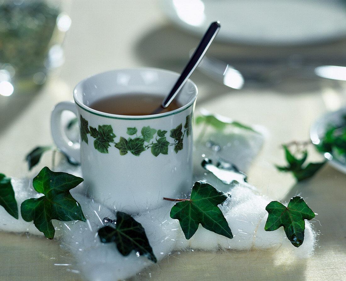 Table decoration with Hedera (ivy), tea cup decorated with cotton star and ivy