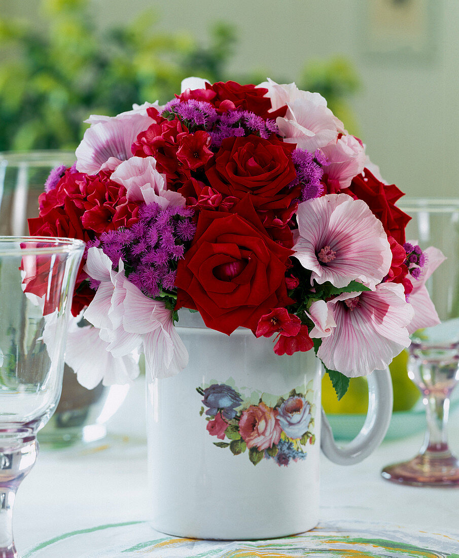 Bouquet of red roses, pink lavatera (cup mallow), blue ageratum