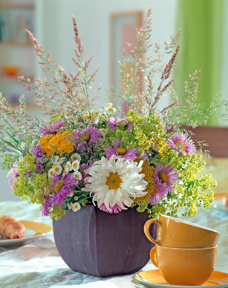 Summer bouquet of marguerite, fine ray aster, lady's mantle, yarrow, motherwort and grasses