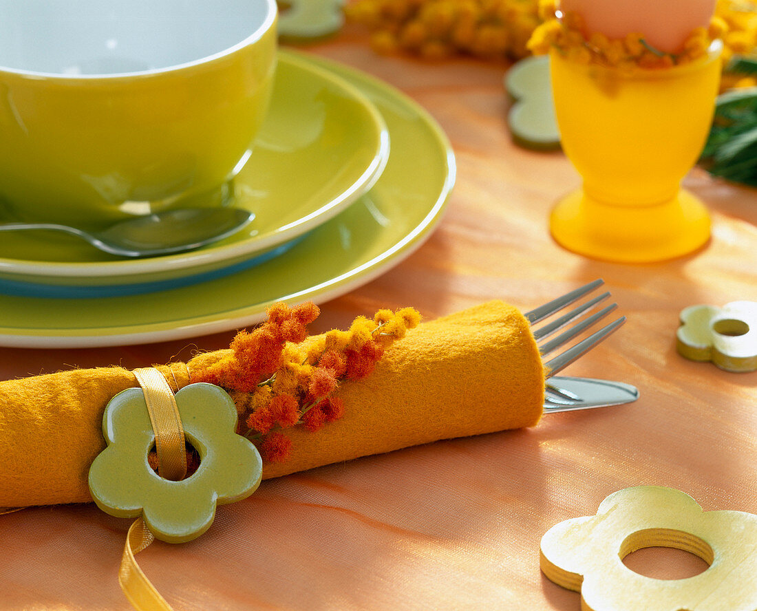 Serviette aus orangenen Filzstoff mit Akazienblüte (Mimosen)