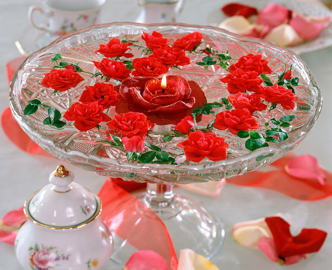 Rose blossoms in a glass bowl with a floating rose candle