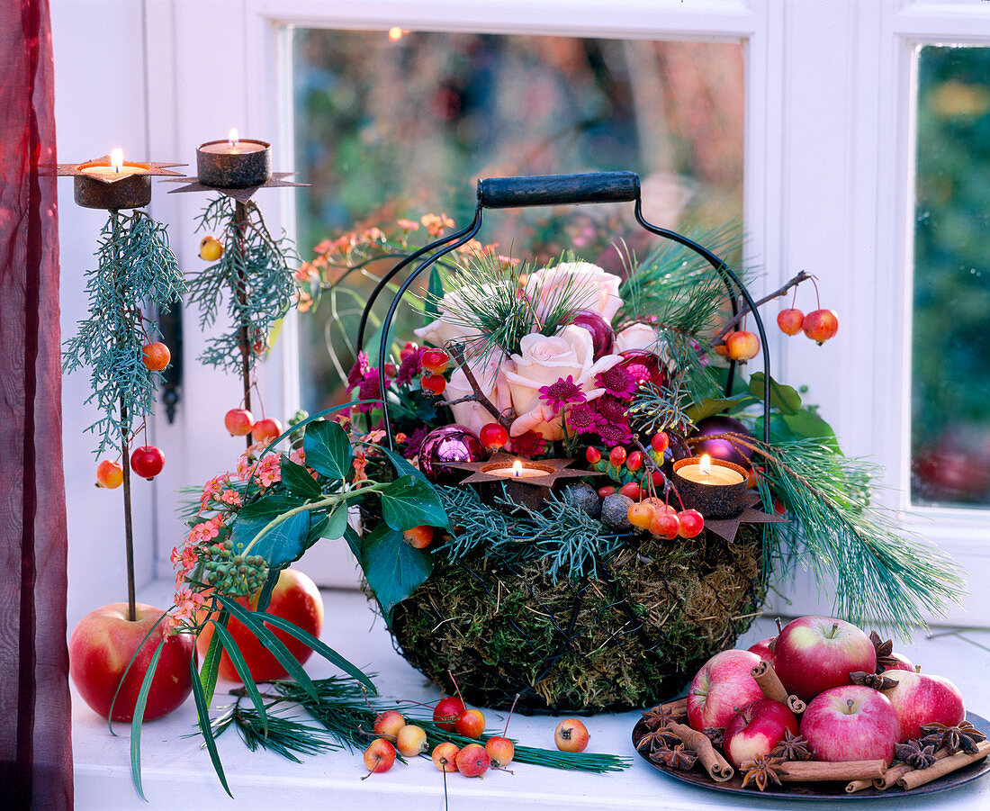 Metal basket lined with moss and decorated with flowers and branches