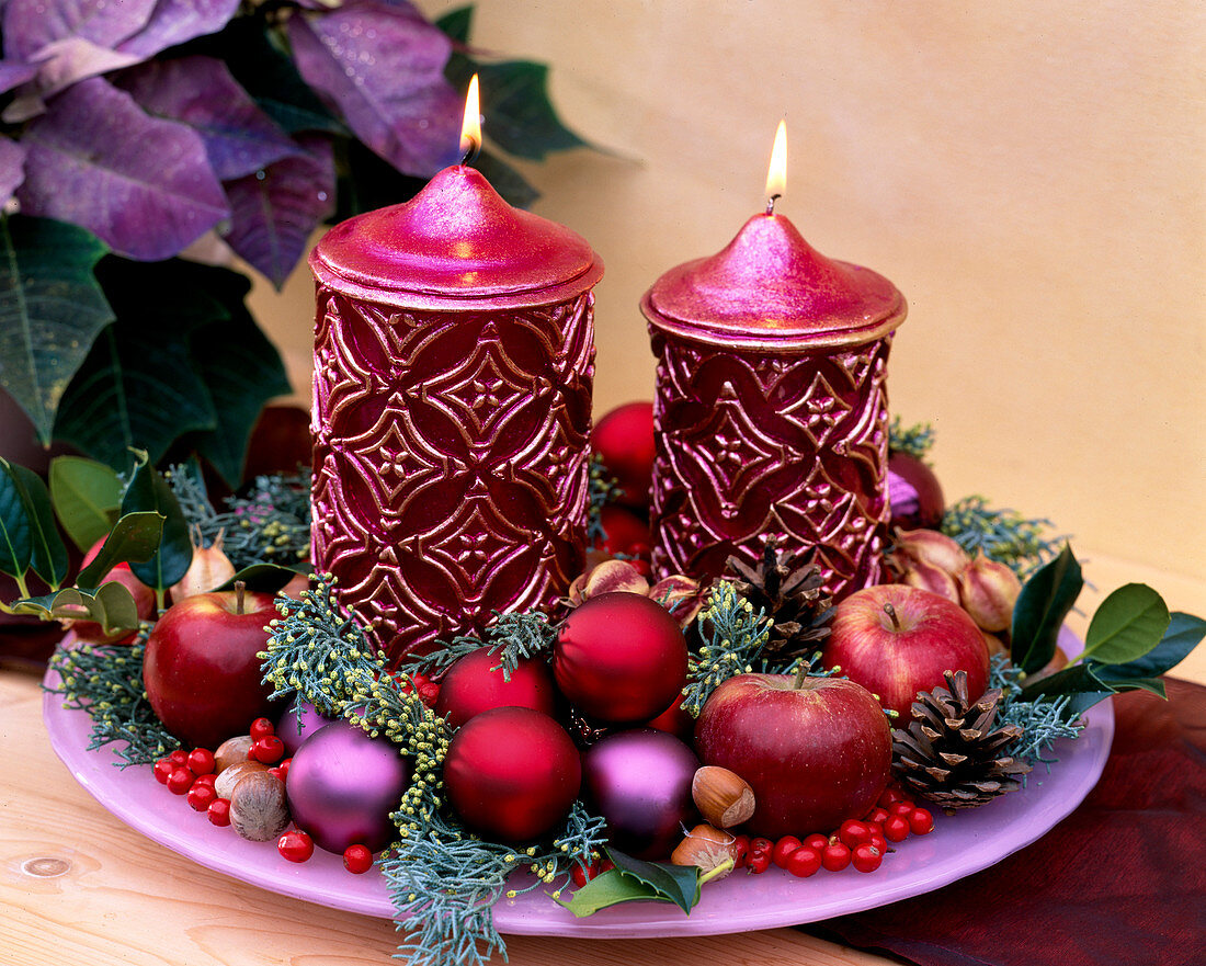 Advent candle decoration with apples, tree balls and Arizona cypress
