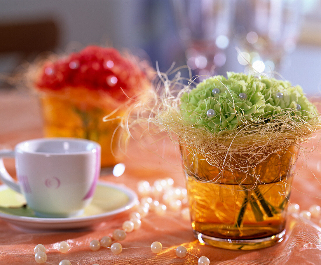 Dianthus (carnations) in glass vase with pearl pins