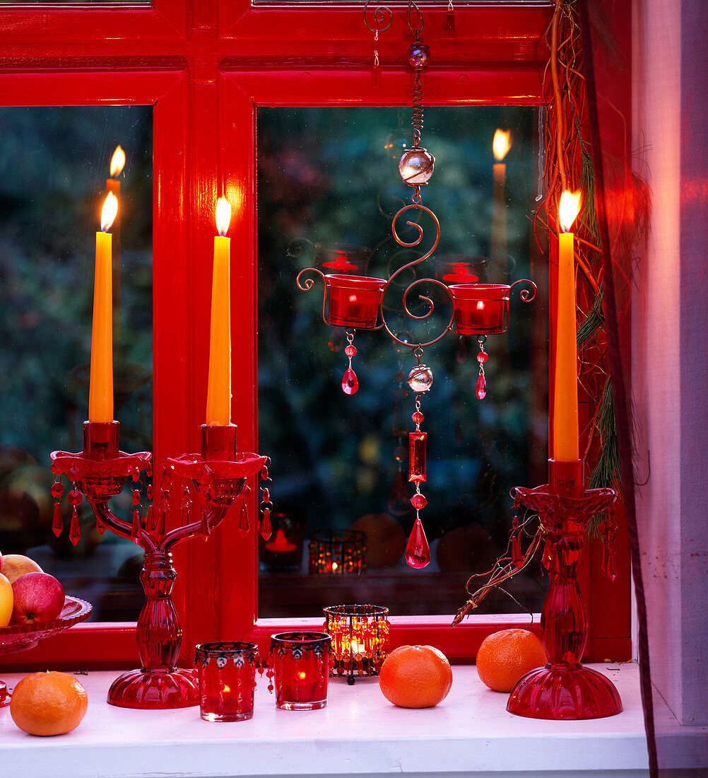 Window decoration with candles and citrus (clementines), malus (apples)