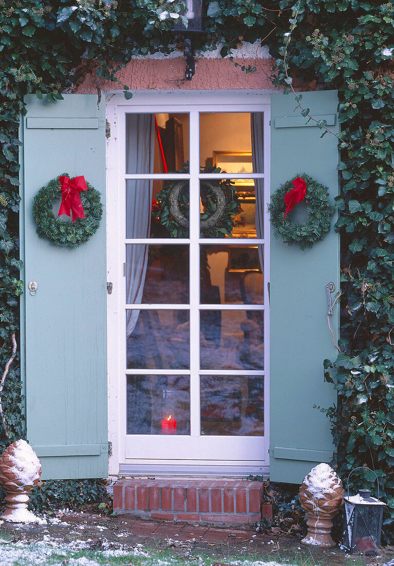 Shutters of the terrace door decorated with artificial wreaths