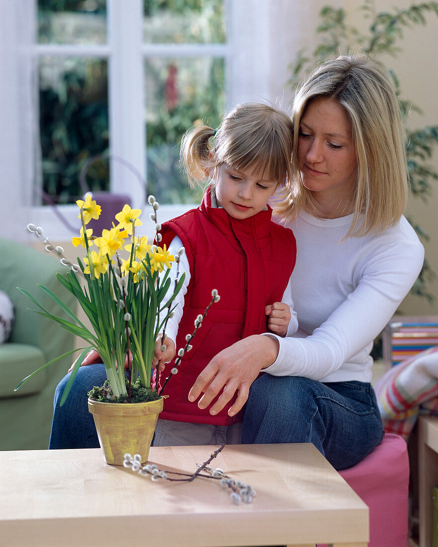 Mother and daughter decorate Narcissus (Narcissus) with Salix