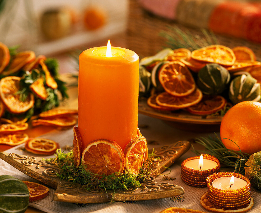 Citrus (orange slices) glued on orange candle. Star plate, moss, tea lights