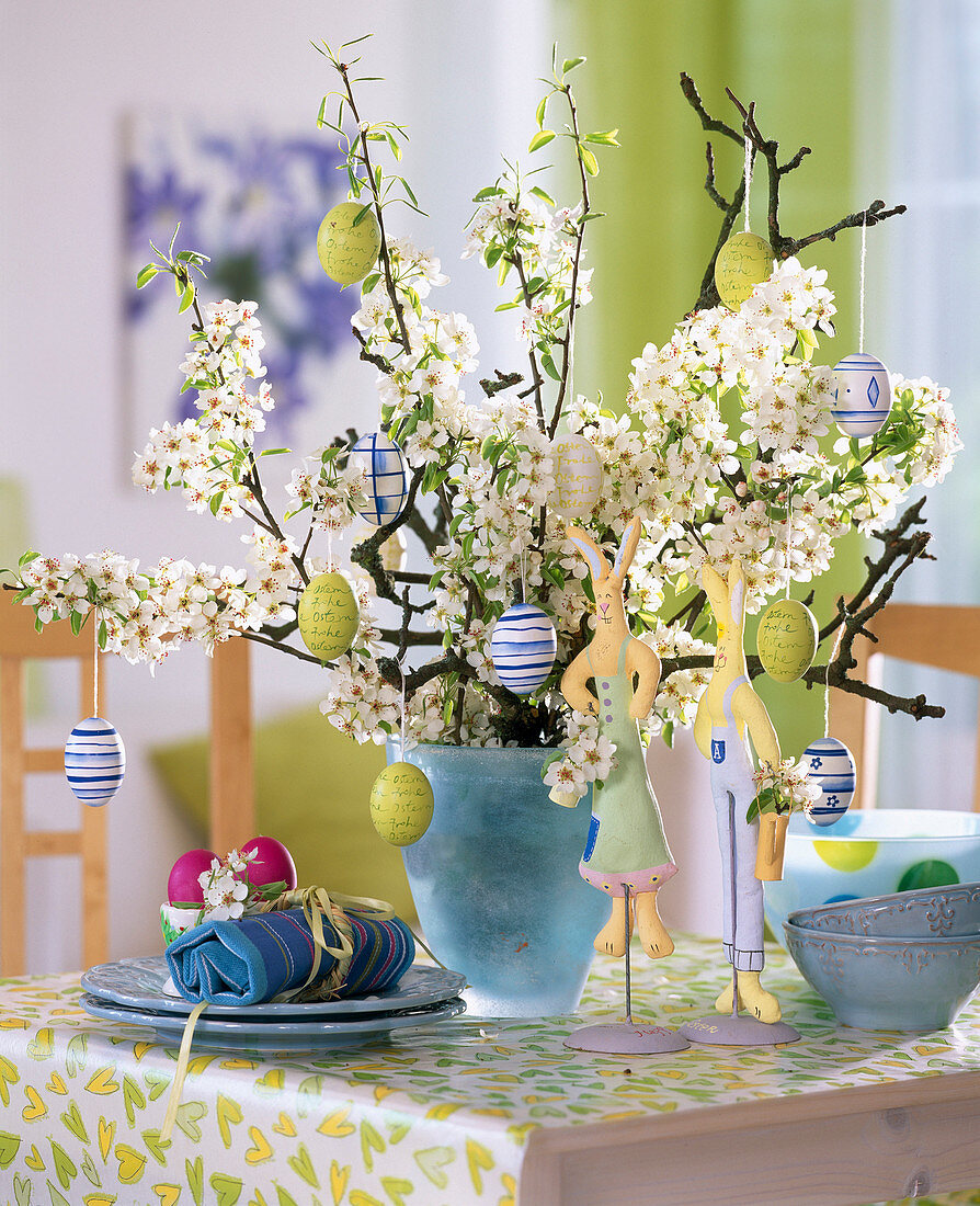 Pyrus (pear branches) in a light blue glass vase