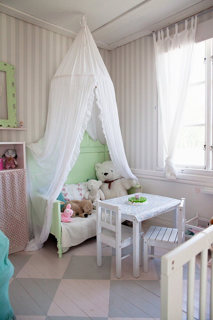 Romantisches Kinderzimmer mit Baldachin über einem alten Bett