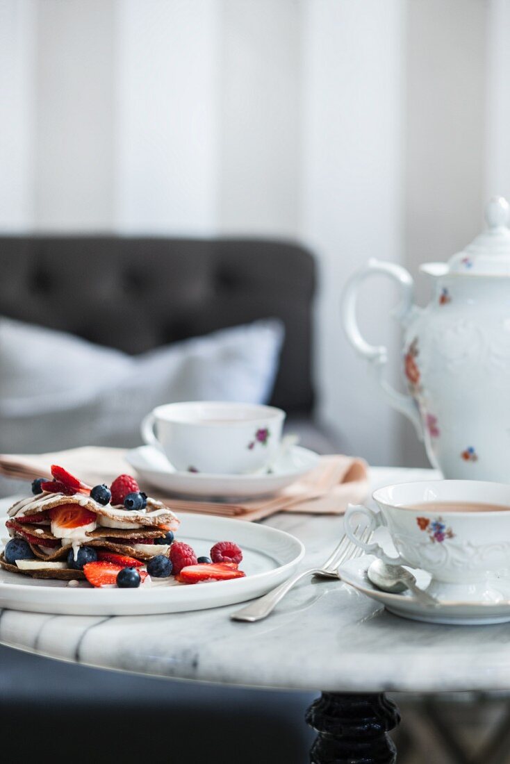 Pancakes with fruits and vanilla cream in a café