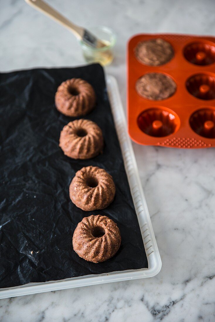 Vegan mini 'Guglhupf' (Bundt) cakes in a baking mould and tray
