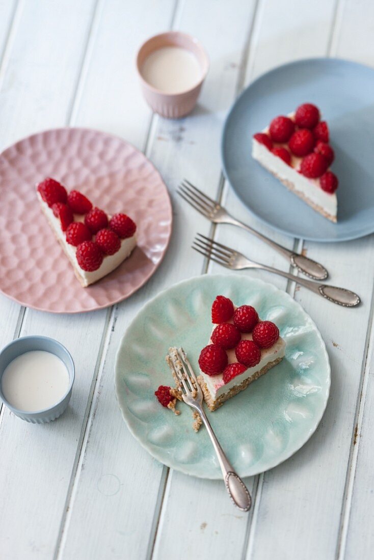 Slices of vegan cheesecake with cashew cream and raspberries