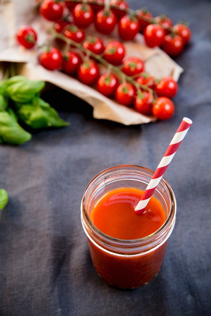 Tomato juice in a glass with a straw