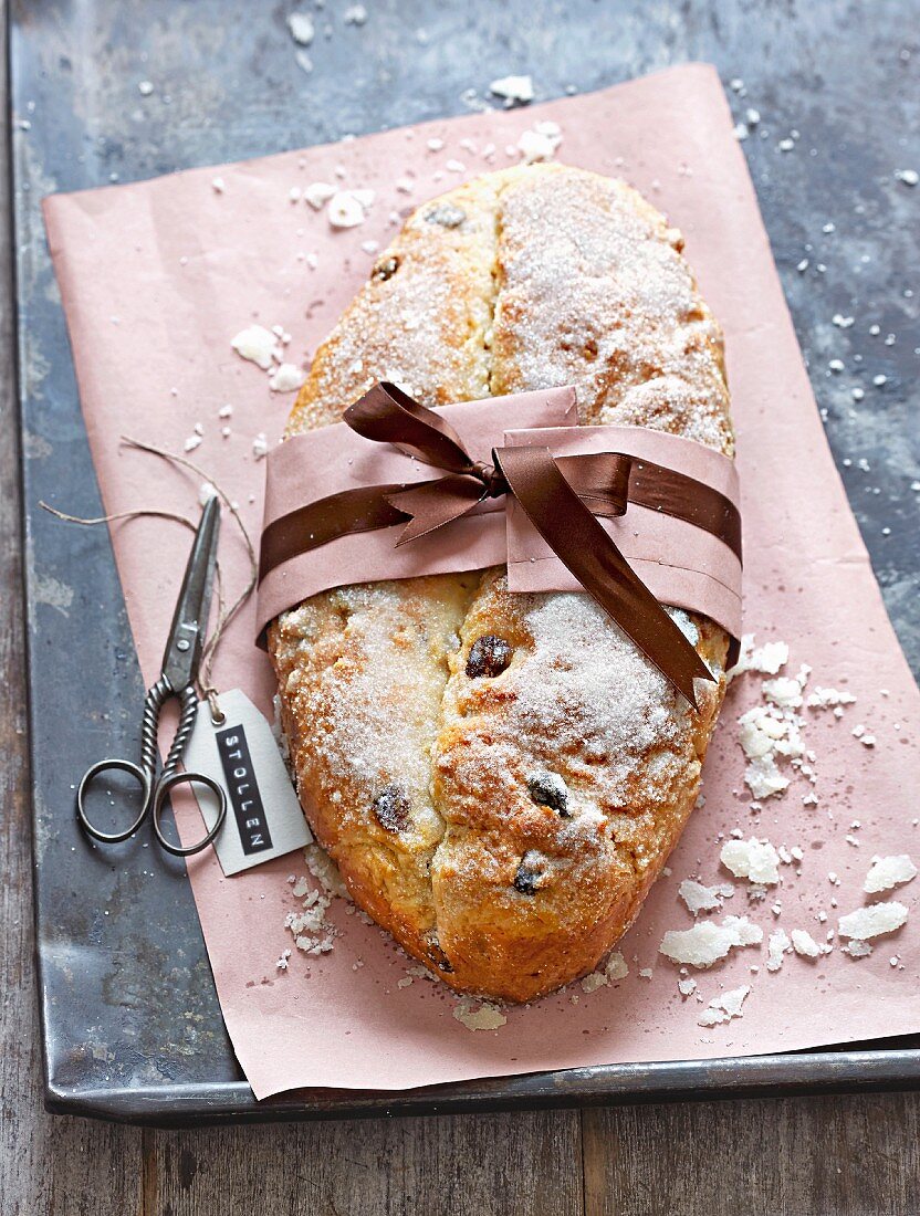 Stollen (German Christmas fruit cake) with oranges, macadamia nuts and cranberries as a gift