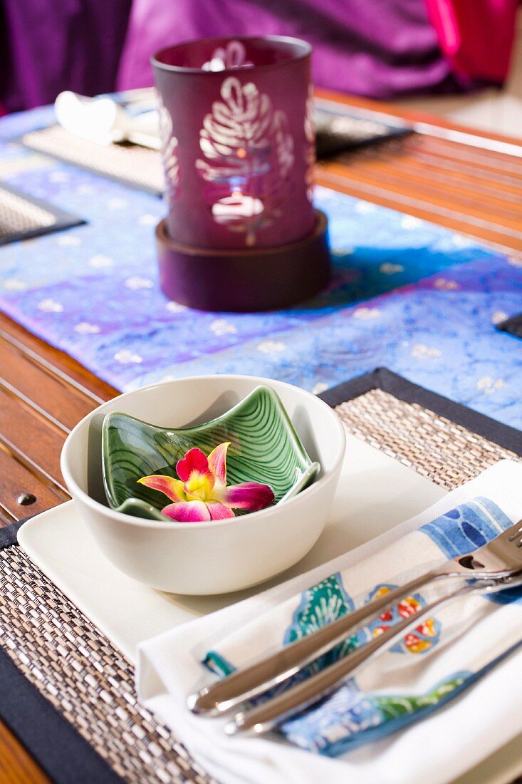 Asiatisch gedeckter Tisch mit Essschälchen, Besteck und Teelicht