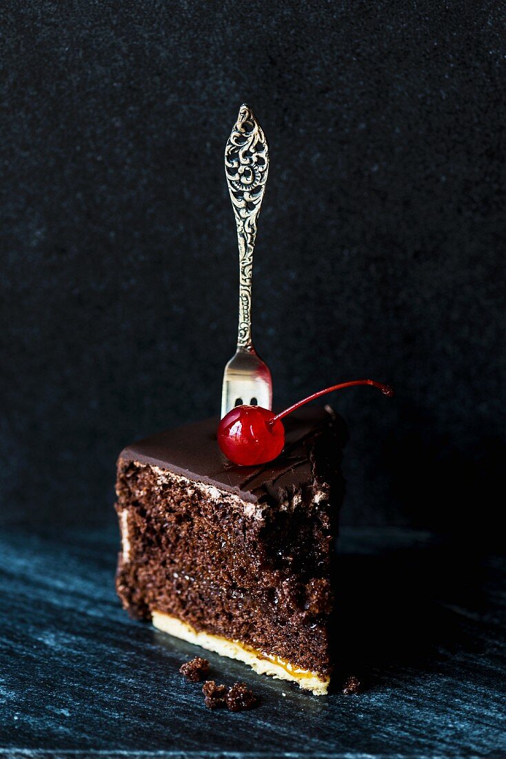 A piece of chocolate with a cocktail and a fork