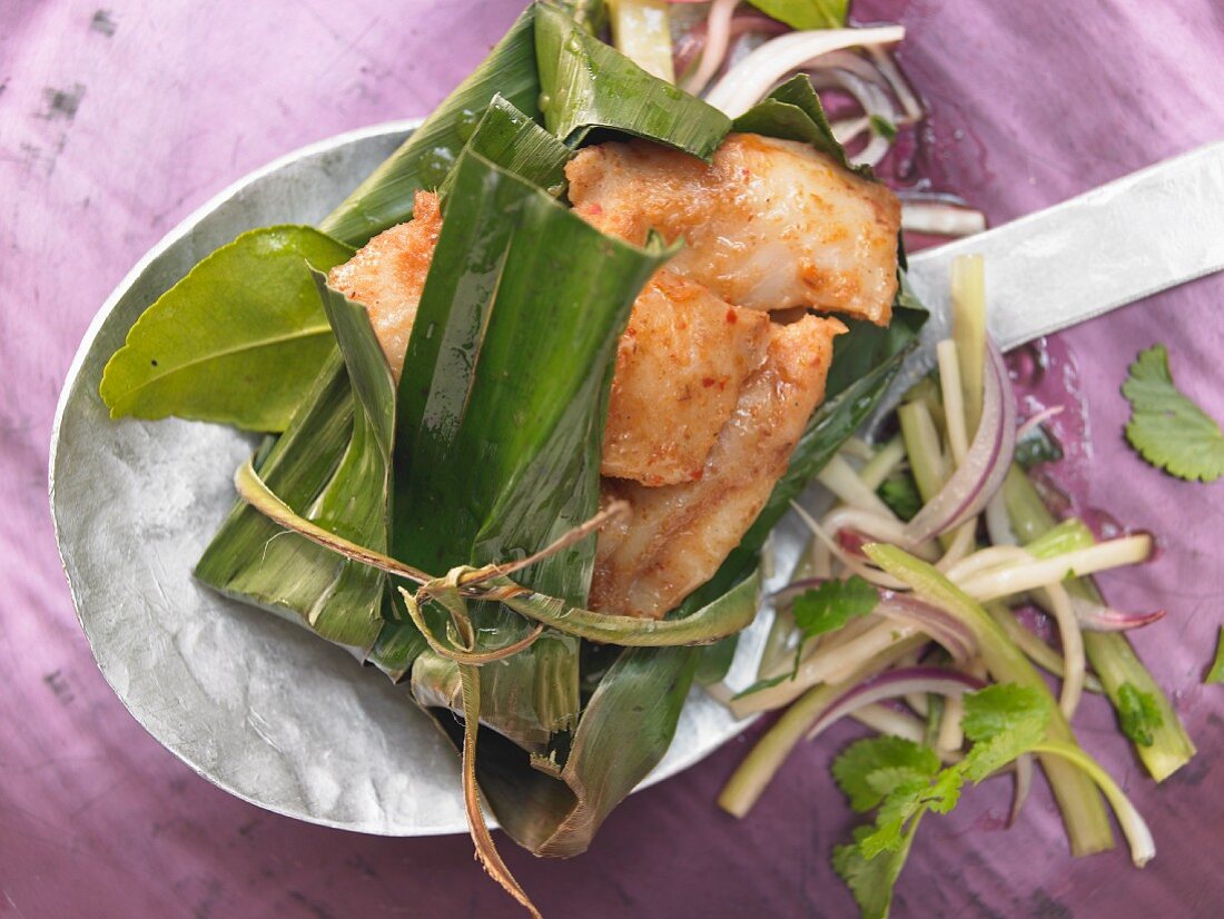 Pangasius fillet steamed in a banana leaf with a green papaya salad