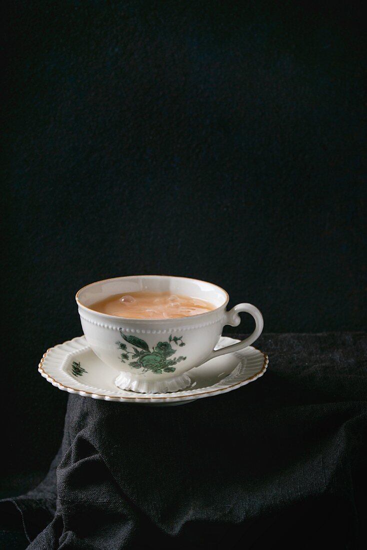 Tee mit Milch in Vintage-Porzellantasse