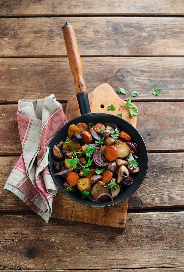 Potatoes, carrots and mushrooms served in a pan