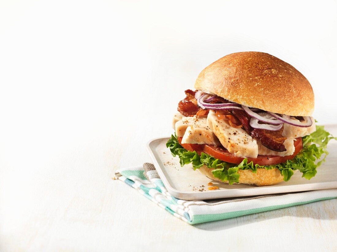 Person Holding a Fried Chicken Sandwich with Lettuce on a Bun