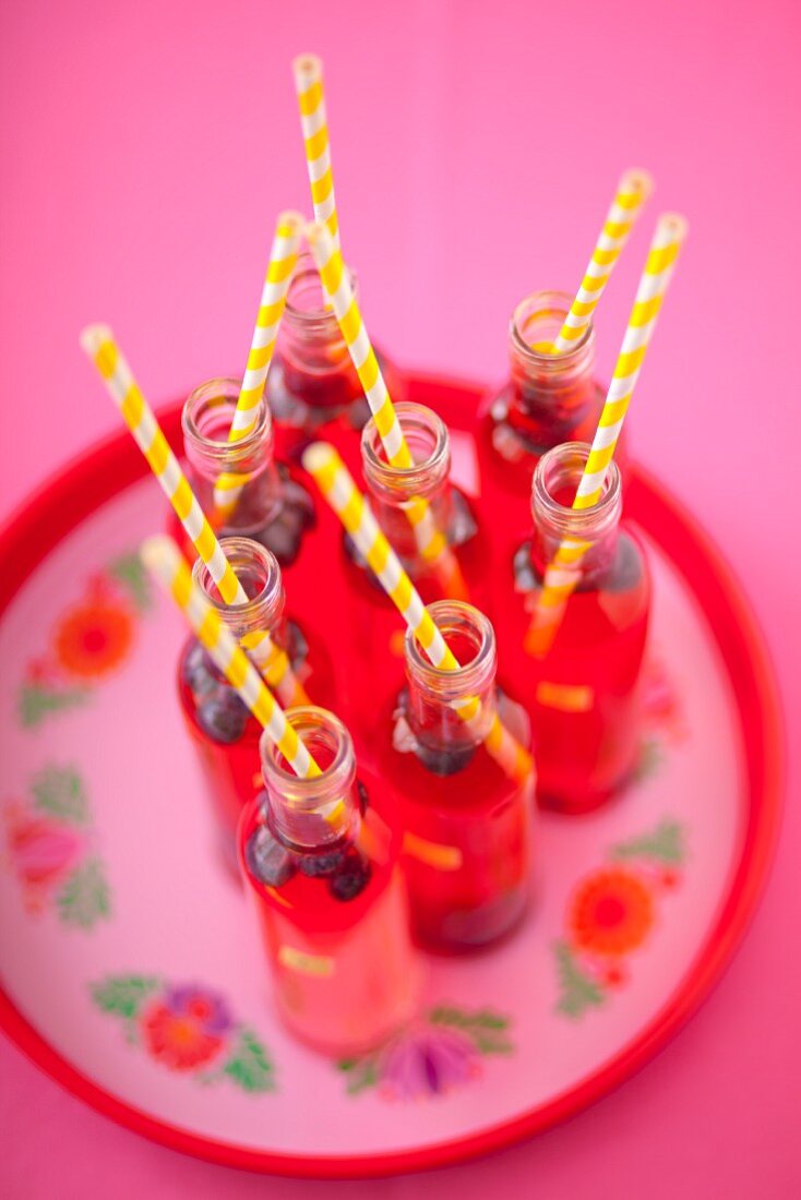 Himbeerlimonade in kleinen Flaschen mit Strohhalmen