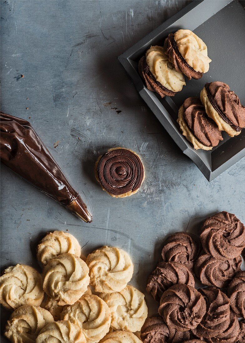 Viennese swirl cookies filled with chocolate cream, on a metal background