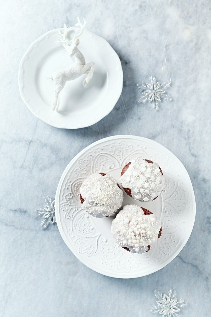 Schokoladenmuffins mit Zuckerglasur und Zuckerperlen zu Weihnachten