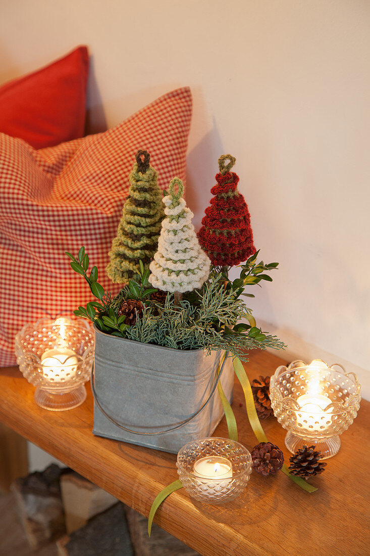 Candle lanterns around arrangement of crocheted fir trees