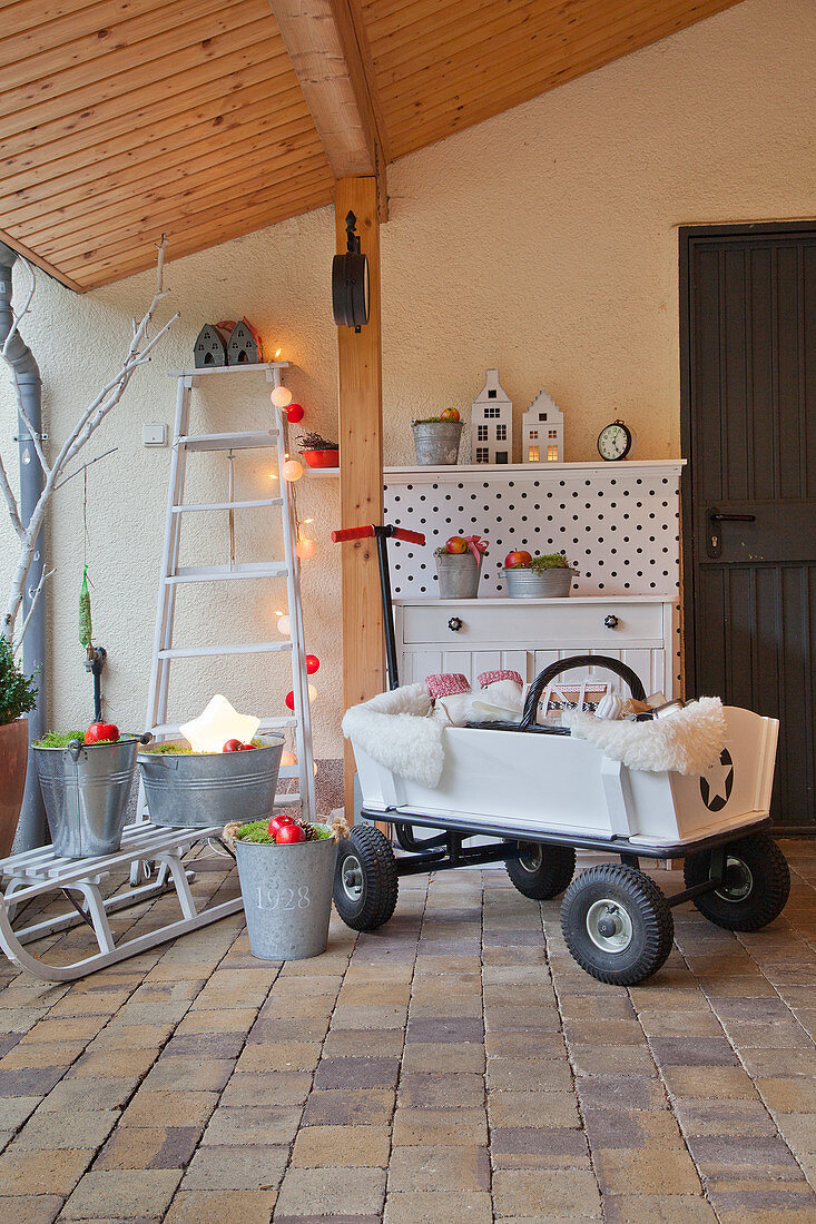 Pull-along cart and Christmas decorations under porch