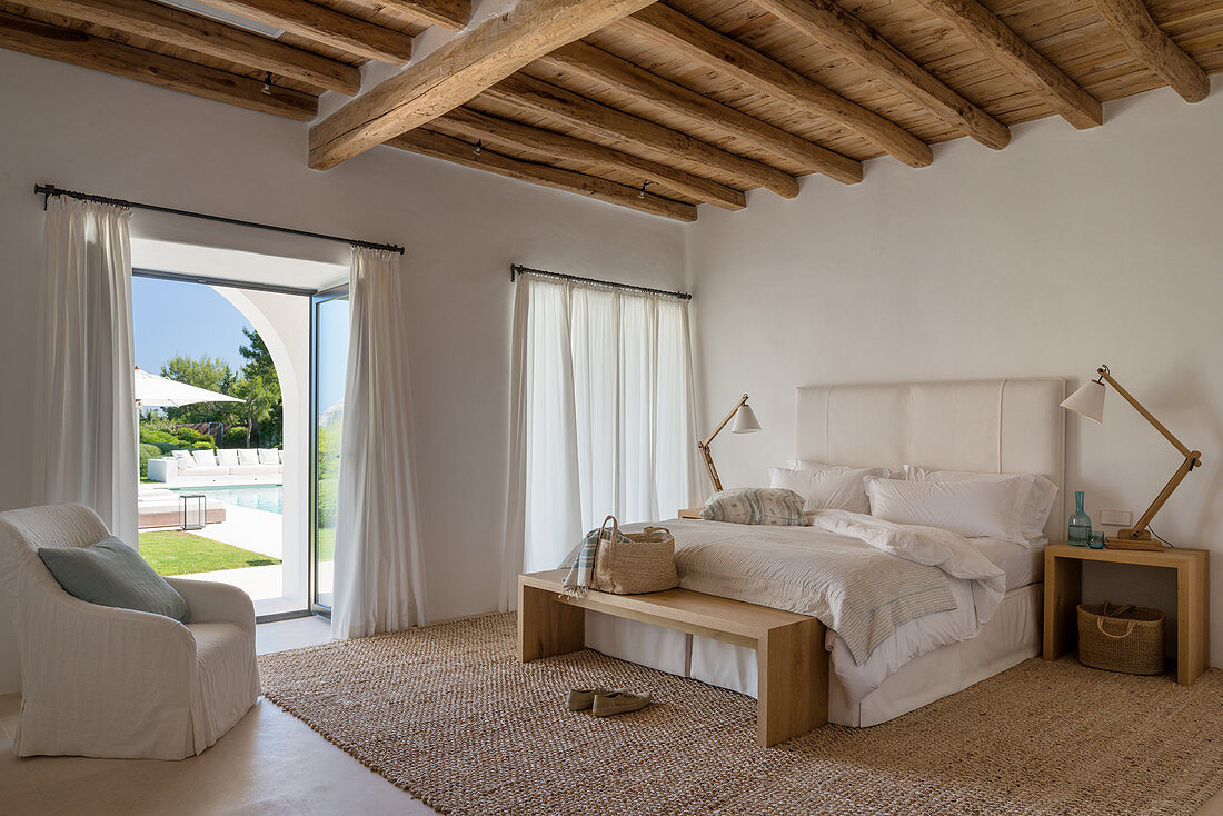 Mediterranean bedroom in natural shades with wood-beamed ceiling