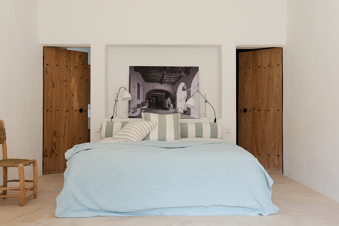 Bed in front of niche flanked by two wooden doors