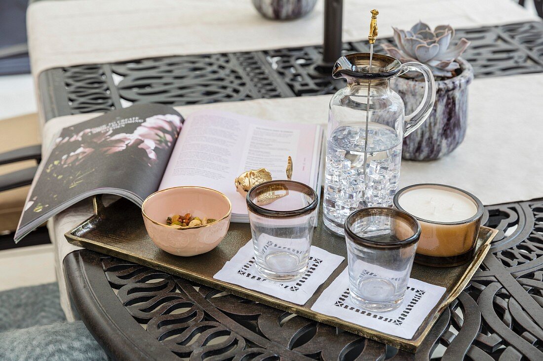 Carafe, glasses, book and candle on gilt tray