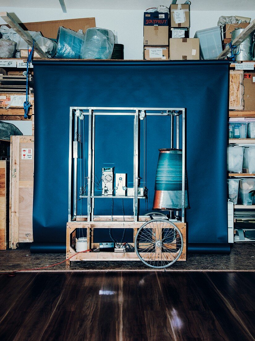 A machine in front of a blue background in the storeroom, designed by Katharina Mischer and Thomas Traxler
