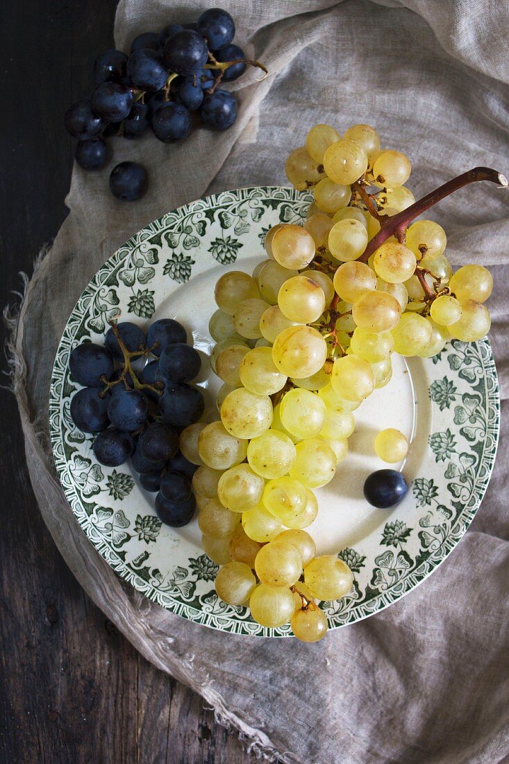 Purple and green grapes on a plate (seen from above)