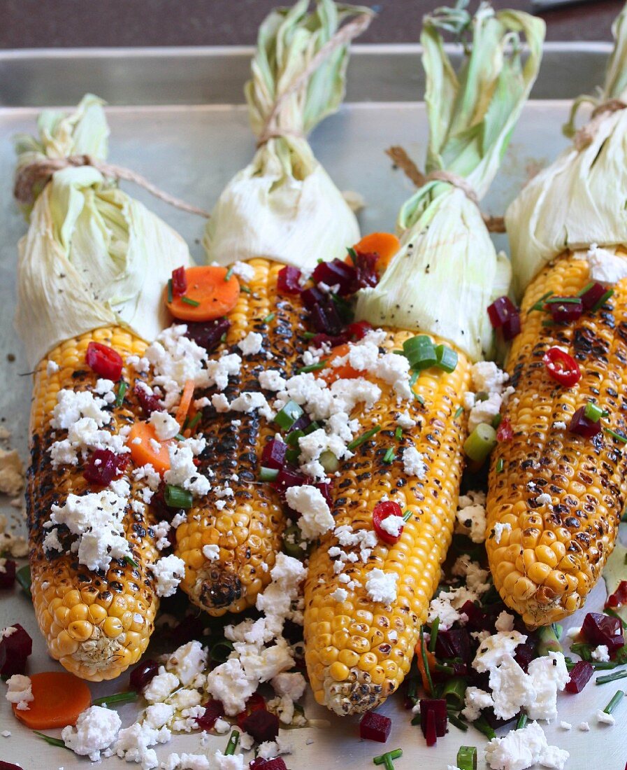 Grilled corn on the cob with vegetables and feta