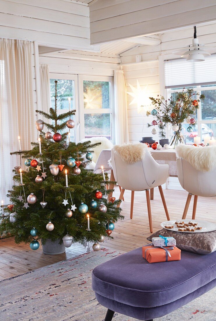 A Christmas tree decorated with modern decorations in a cottage