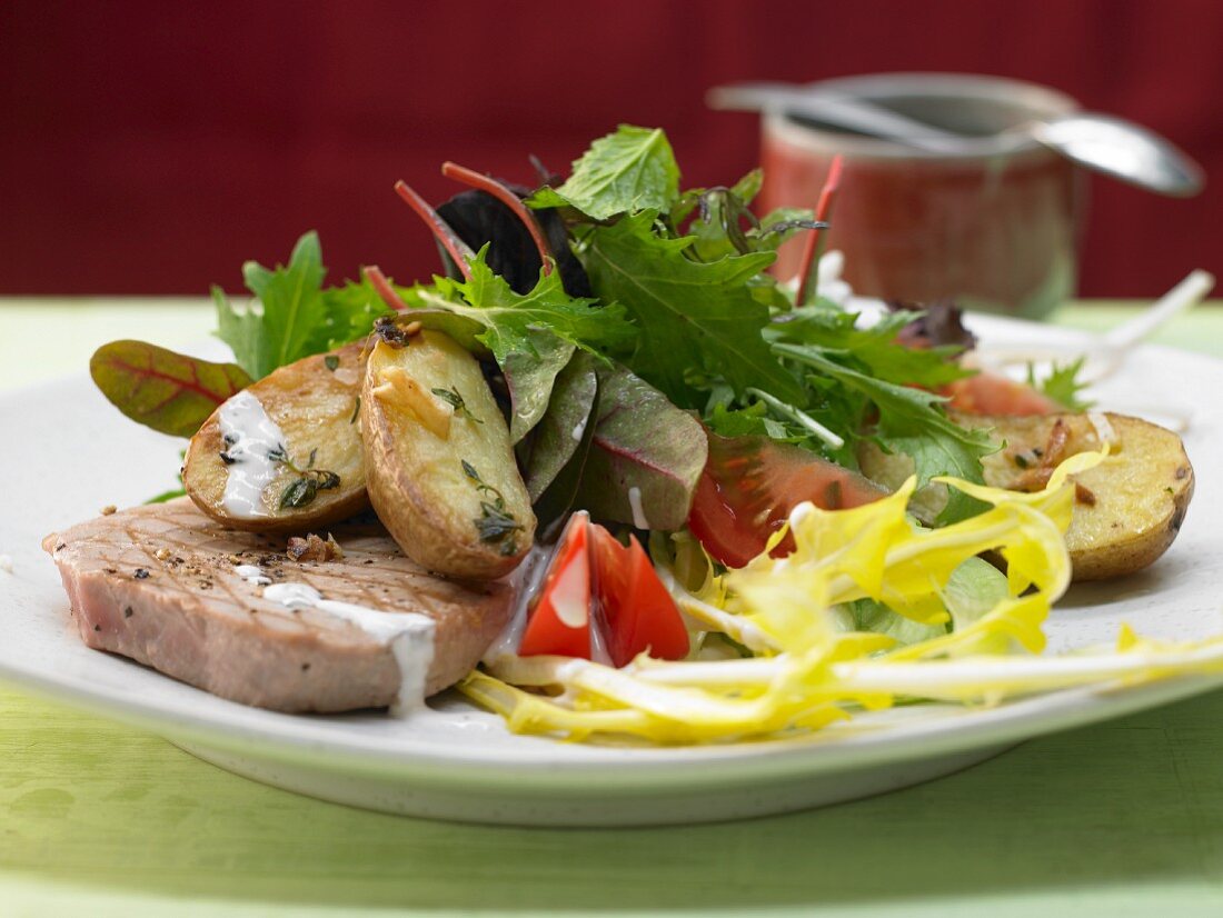 Gegrillter Thunfisch mit gerösteten Kartoffeln, dazu Blattsalat mit Pfefferdressing